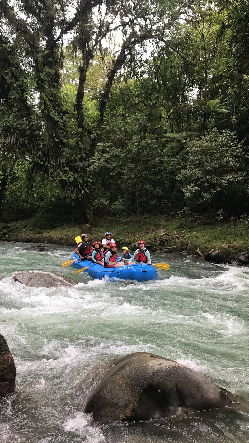 Thrilling rafting experience on the Pacuare River with a group of friends navigating the exciting rapids together.